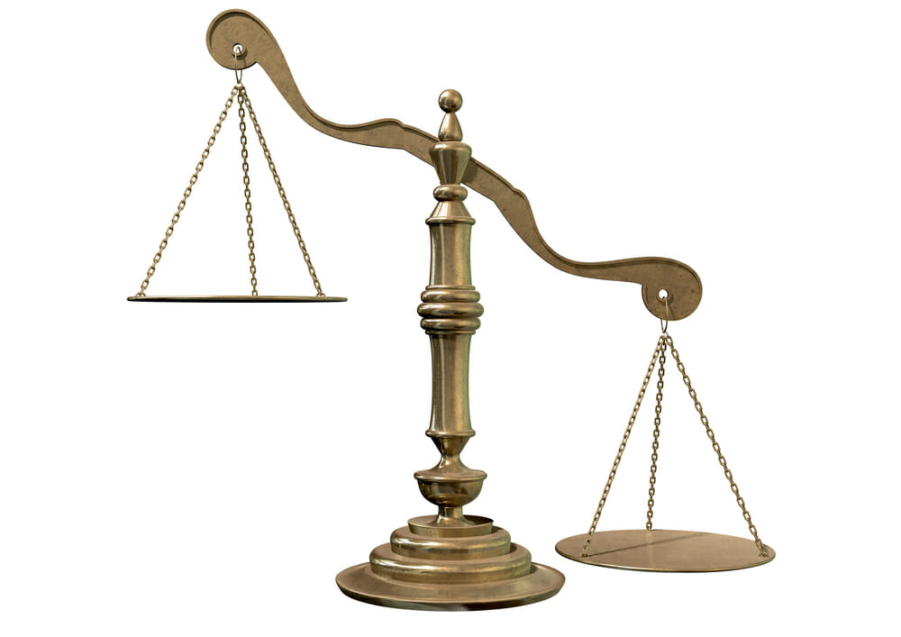An empty bronze justice scale with one side outweighing the the other on an isolated background