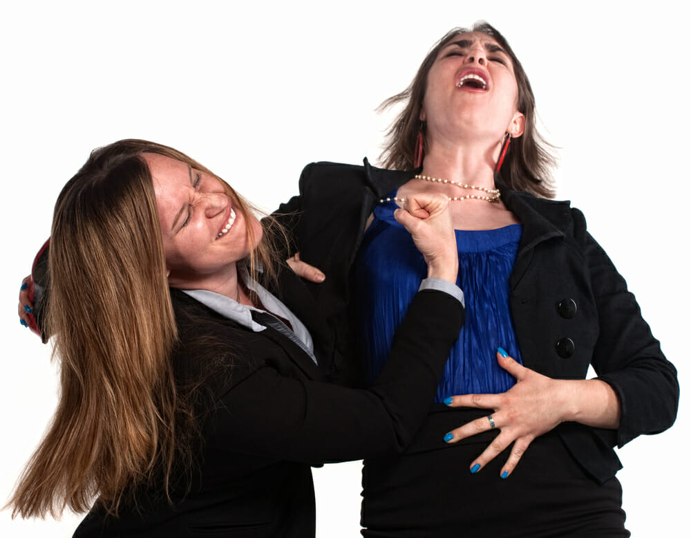 Angry businesswoman in a fist fight over white background