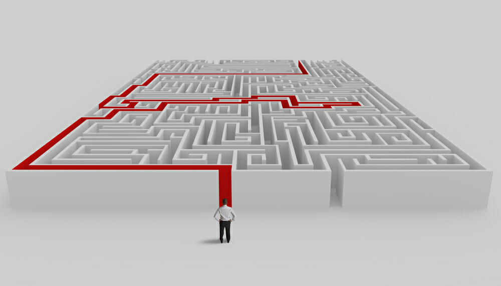 Businessman in front of a maze with solution