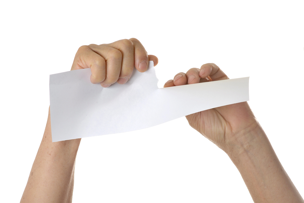 Hands tearing paper sheet